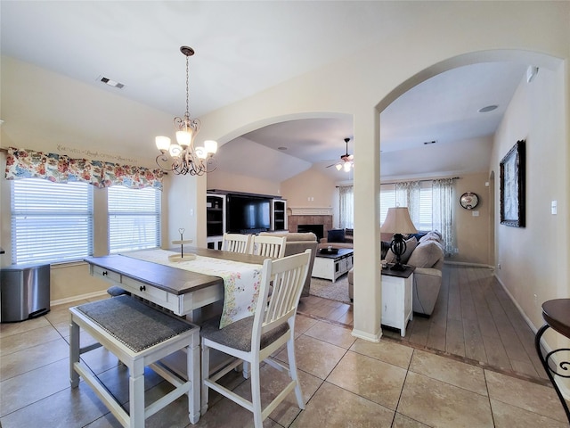 dining area with visible vents, ceiling fan, arched walkways, and light tile patterned floors
