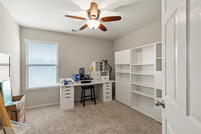 office area with visible vents, ceiling fan, light carpet, and a healthy amount of sunlight