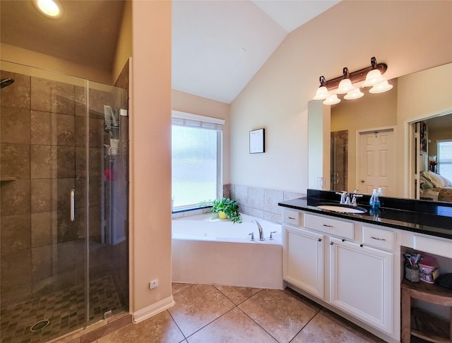 bathroom featuring a bath, a shower stall, vanity, vaulted ceiling, and tile patterned floors