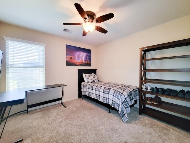 carpeted bedroom featuring ceiling fan and visible vents