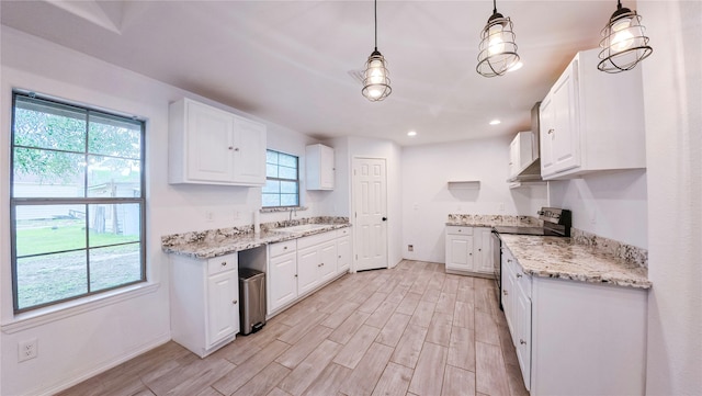 kitchen featuring light wood-type flooring, white cabinetry, under cabinet range hood, electric stove, and a sink