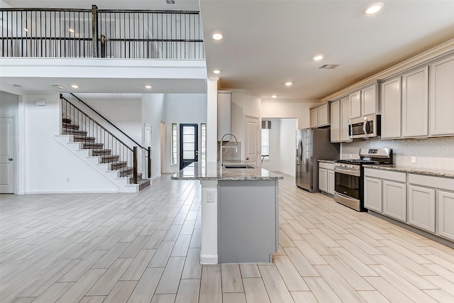 3007 Velda May Dr, Richmond, TX 77406 - kitchen featuring tasteful backsplash, wood finish floors, visible vents, stainless steel appliances, and a sink