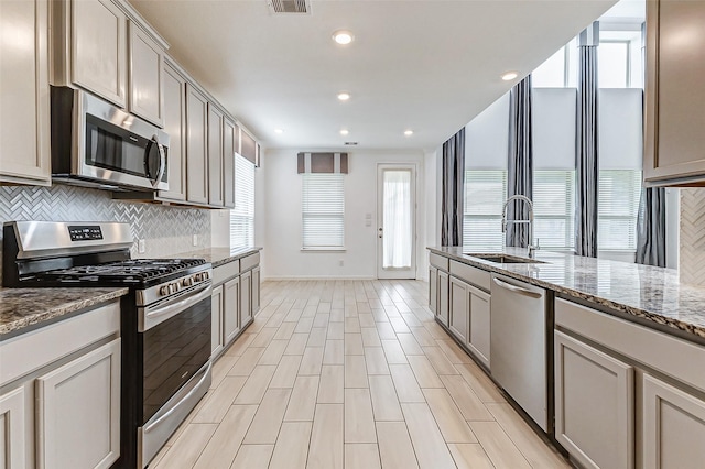 3007 Velda May Dr, Richmond, TX 77406 - kitchen featuring stone countertops, backsplash, visible vents, appliances with stainless steel finishes, and a sink