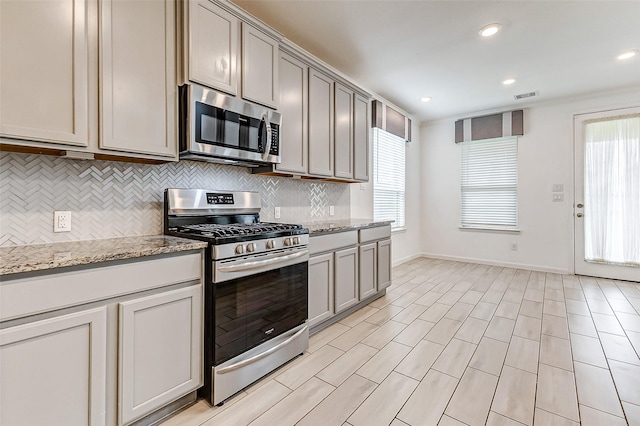 3007 Velda May Dr, Richmond, TX 77406 - kitchen with tasteful backsplash, visible vents, gray cabinets, appliances with stainless steel finishes, and baseboards