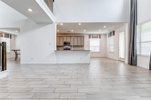 3007 Velda May Dr, Richmond, TX 77406 - kitchen with backsplash, a wealth of natural light, a towering ceiling, and stainless steel appliances