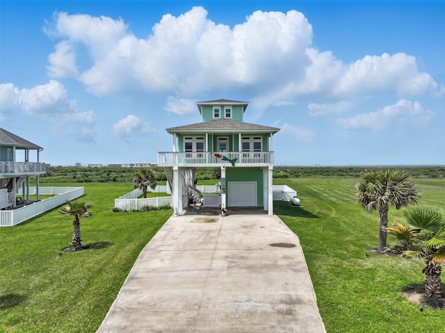 4102 Kiva Rd, Galveston, TX 77554 - view of front facade featuring a front yard, driveway, an attached garage, and covered porch