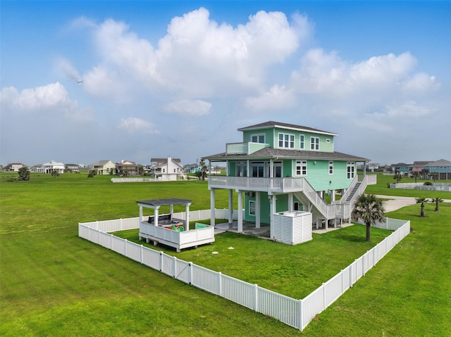 4102 Kiva Rd, Galveston, TX 77554 - rear view of property with a pergola, stairway, a fenced backyard, and a lawn