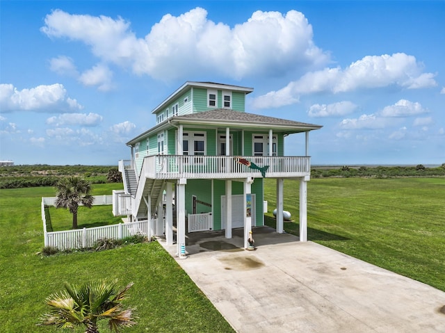 4102 Kiva Rd, Galveston, TX 77554 - raised beach house with a front yard, a porch, stairs, and concrete driveway