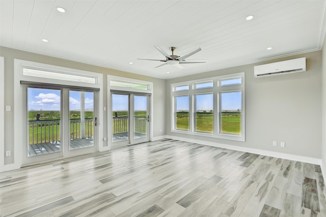 4102 Kiva Rd, Galveston, TX 77554 - unfurnished living room with light wood-style floors, a wall mounted AC, ceiling fan, and plenty of natural light