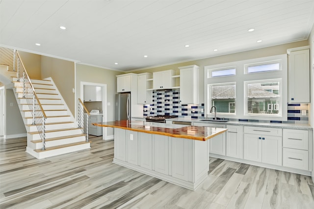 4102 Kiva Rd, Galveston, TX 77554 - kitchen featuring open shelves, a sink, freestanding refrigerator, independent washer and dryer, and a kitchen island