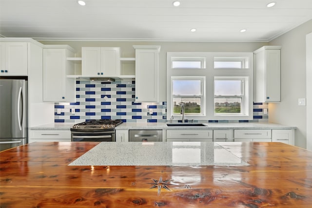 4102 Kiva Rd, Galveston, TX 77554 - kitchen with butcher block counters, open shelves, appliances with stainless steel finishes, a sink, and backsplash