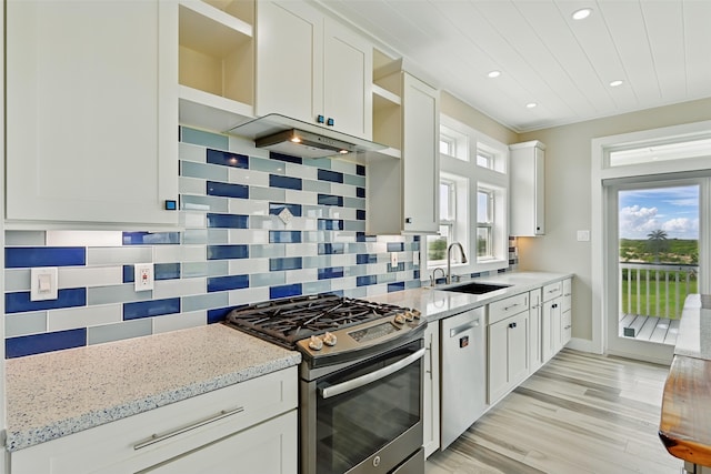 4102 Kiva Rd, Galveston, TX 77554 - kitchen featuring tasteful backsplash, open shelves, a sink, appliances with stainless steel finishes, and white cabinetry