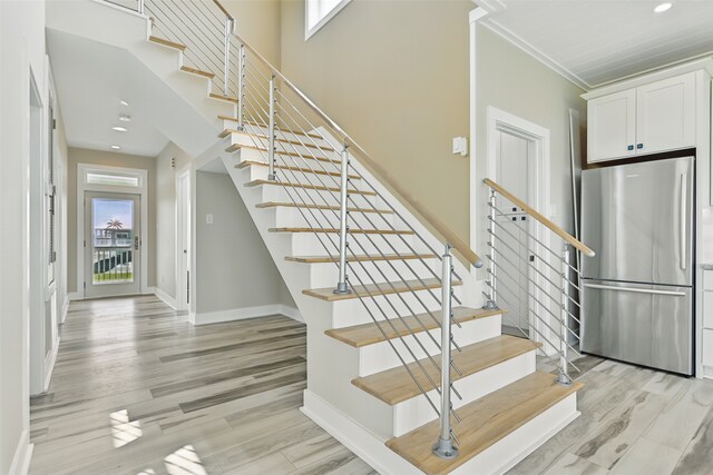 4102 Kiva Rd, Galveston, TX 77554 - stairway featuring wood finished floors, baseboards, ornamental molding, and recessed lighting