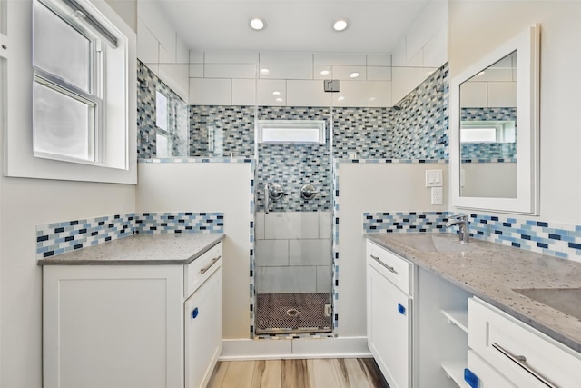 4102 Kiva Rd, Galveston, TX 77554 - bathroom featuring a shower stall, a sink, backsplash, and wood finished floors