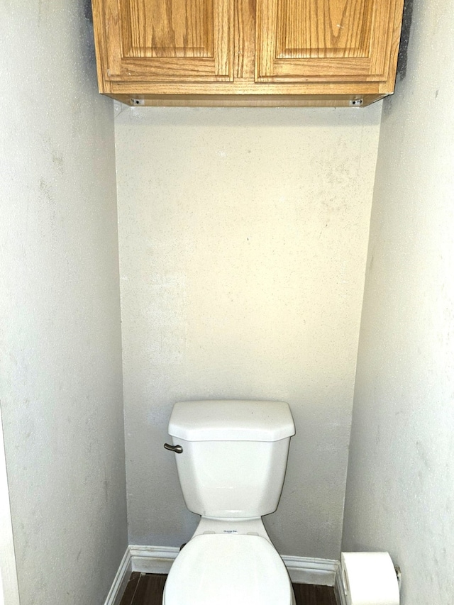 bathroom featuring baseboards and toilet