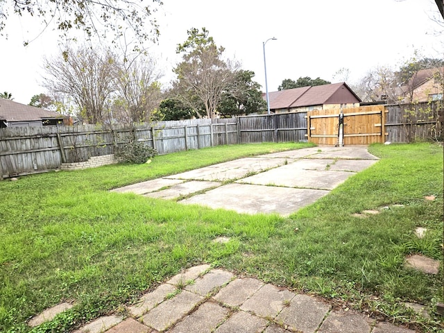view of yard featuring a fenced backyard and a gate