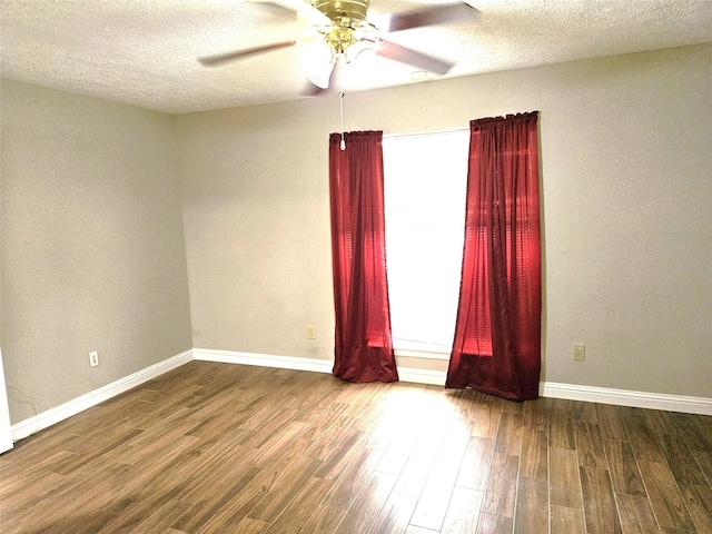 empty room with baseboards, wood finished floors, and ceiling fan