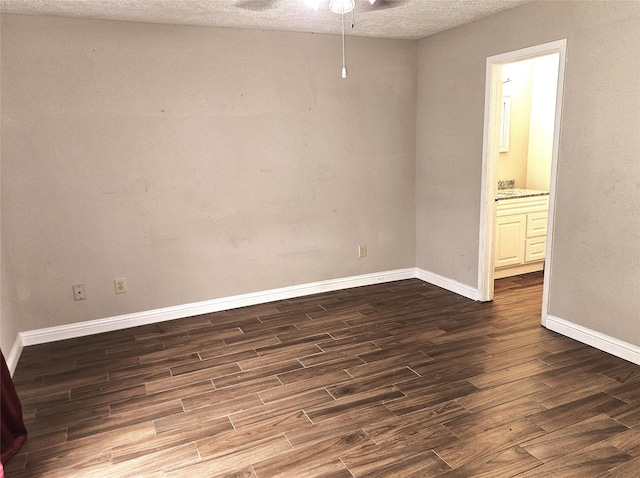 empty room featuring ceiling fan, a textured ceiling, baseboards, and dark wood finished floors