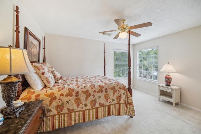 carpeted bedroom with a textured ceiling, baseboards, a ceiling fan, and visible vents
