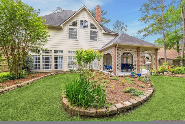 back of house with a yard, a shingled roof, fence, and a patio area