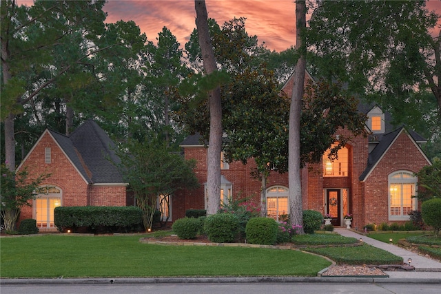 1906 Riverglen Forest Dr, Kingwood, TX 77345 - view of front of house with brick siding, a yard, and a shingled roof