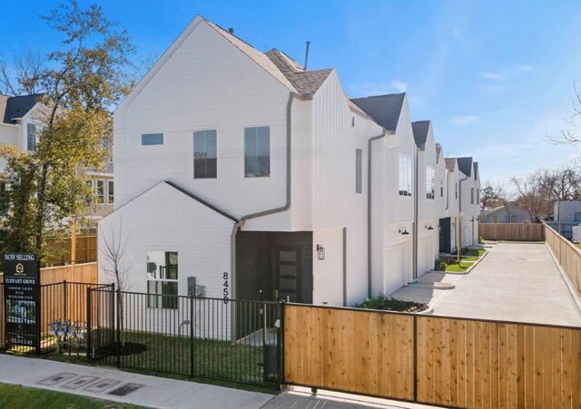 845 Elkhart St Unit C, Houston, TX 77091 - view of front of house featuring a fenced front yard, a residential view, a shingled roof, and a garage