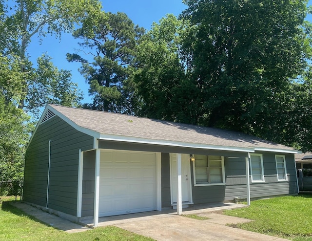 view of front of house featuring roof with shingles, driveway, and a front lawn