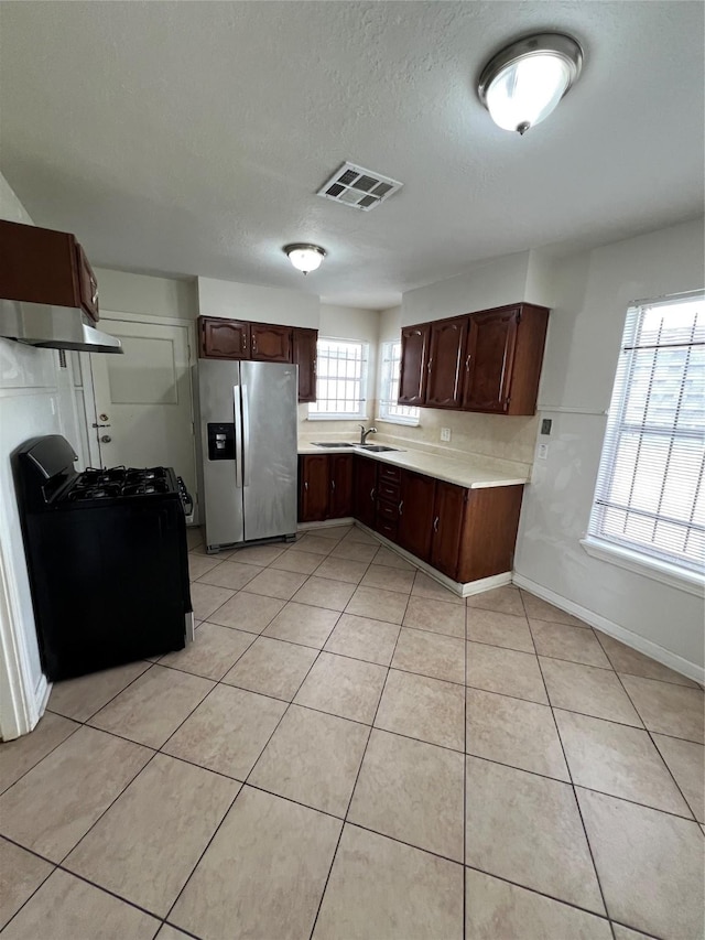 206 W 44th St, Houston, TX 77018 - kitchen featuring gas stove, light tile patterned floors, stainless steel refrigerator with ice dispenser, visible vents, and a sink
