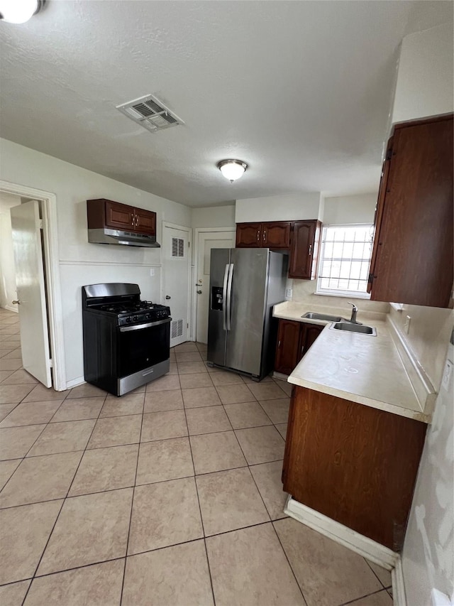 206 W 44th St, Houston, TX 77018 - kitchen featuring stainless steel fridge with ice dispenser, light countertops, light tile patterned flooring, visible vents, and black gas range
