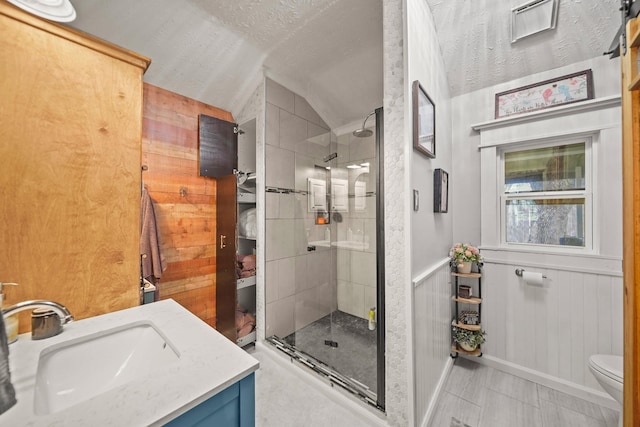 bathroom featuring a shower stall, lofted ceiling, toilet, and vanity