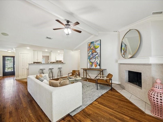 2510 Cobble Ridge Dr, Sugar Land, TX 77498 - living room featuring wood finished floors, a ceiling fan, a tile fireplace, baseboards, and ornamental molding