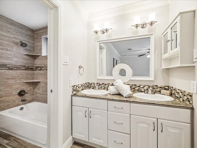 2510 Cobble Ridge Dr, Sugar Land, TX 77498 - bathroom with crown molding, double vanity, washtub / shower combination, decorative backsplash, and wood finished floors