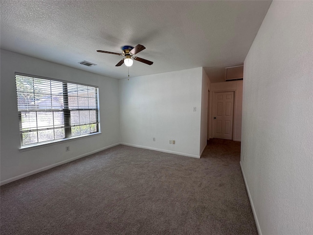 carpeted empty room featuring baseboards, visible vents, a textured ceiling, and ceiling fan