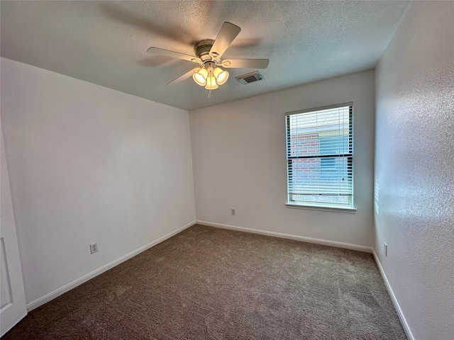 empty room featuring a textured ceiling, visible vents, baseboards, a ceiling fan, and carpet floors