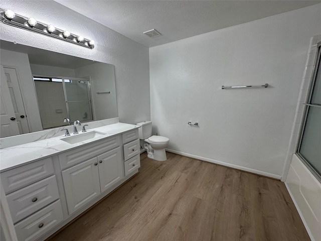 full bathroom featuring a shower with shower door, wood finished floors, visible vents, and toilet