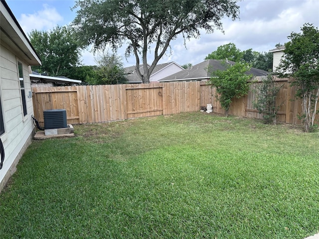 view of yard with a fenced backyard and central AC