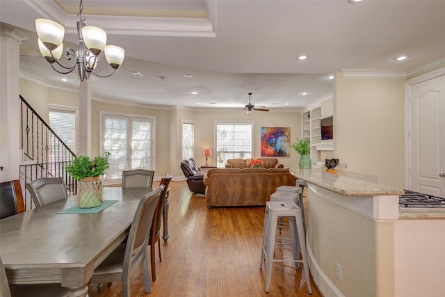 dining space with ornamental molding, stairway, light wood-type flooring, recessed lighting, and ceiling fan with notable chandelier