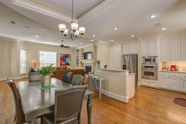 dining space with crown molding, ceiling fan with notable chandelier, and visible vents