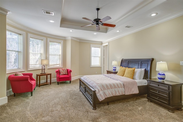 bedroom with crown molding, light colored carpet, a tray ceiling, and visible vents