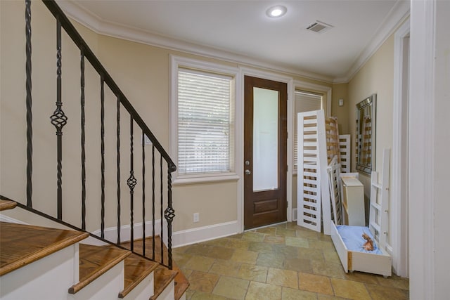 entryway featuring stone finish floor, ornamental molding, baseboards, and visible vents