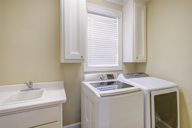laundry area featuring cabinet space, a sink, and washer and clothes dryer