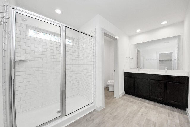 2906 Chase Cross Ln, Houston, TX 77047 - full bathroom with toilet, a stall shower, wood finished floors, double vanity, and recessed lighting