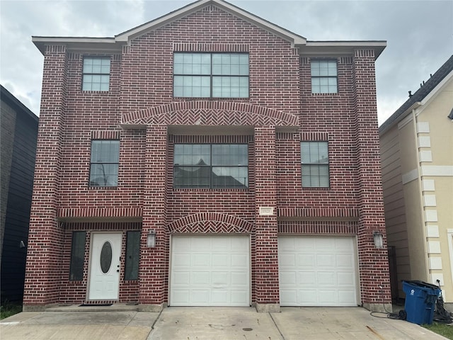 traditional-style house with concrete driveway, brick siding, and an attached garage