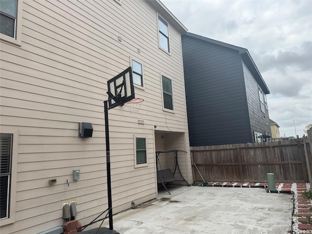 view of property exterior featuring a patio area and fence