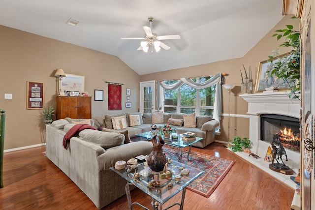 225 Mesa Vw, Montgomery, TX 77316 - living room featuring vaulted ceiling, a ceiling fan, baseboards, a lit fireplace, and wood finished floors