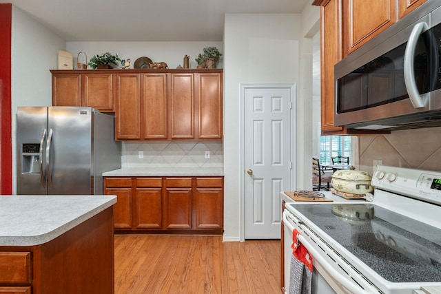 225 Mesa Vw, Montgomery, TX 77316 - kitchen with appliances with stainless steel finishes, light wood-type flooring, brown cabinets, and light countertops