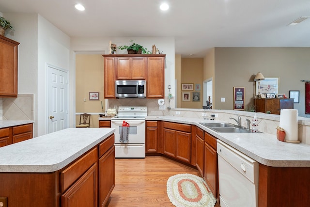 225 Mesa Vw, Montgomery, TX 77316 - kitchen featuring white appliances, a sink, light countertops, light wood finished floors, and decorative backsplash
