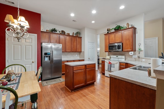 225 Mesa Vw, Montgomery, TX 77316 - kitchen featuring stainless steel appliances, light wood finished floors, light countertops, decorative backsplash, and a chandelier