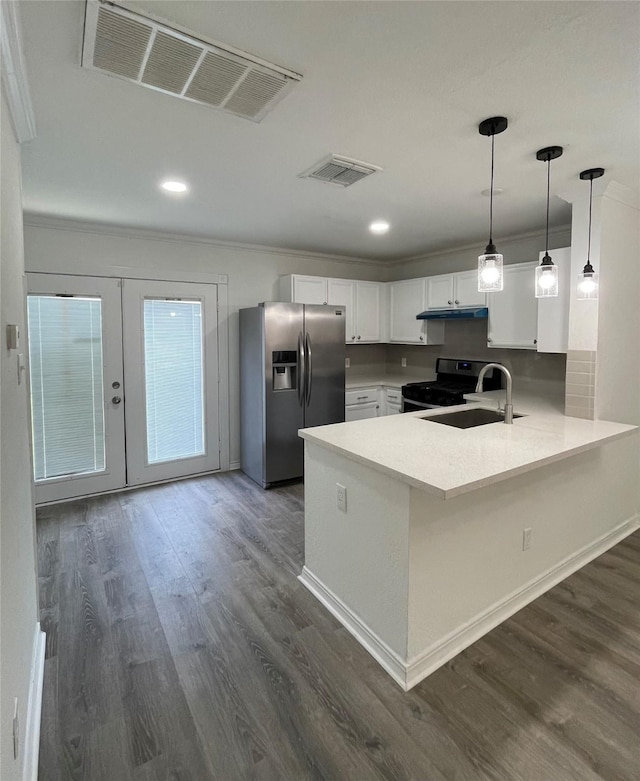 kitchen featuring visible vents, stainless steel refrigerator with ice dispenser, gas range, and a peninsula