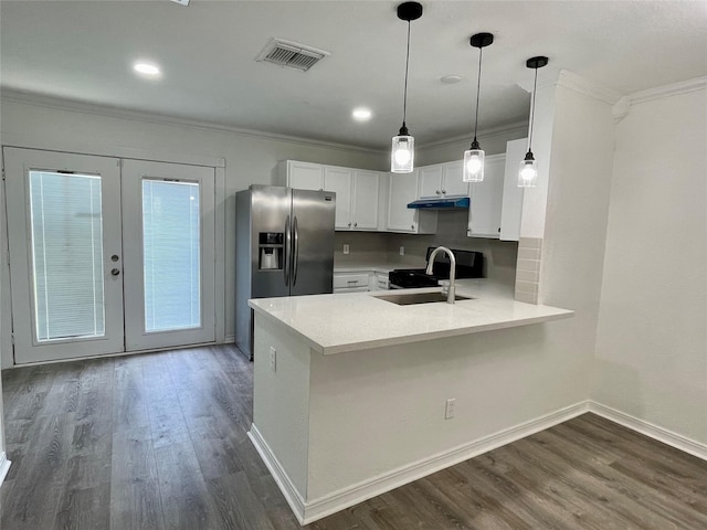 kitchen with under cabinet range hood, a sink, ornamental molding, and visible vents